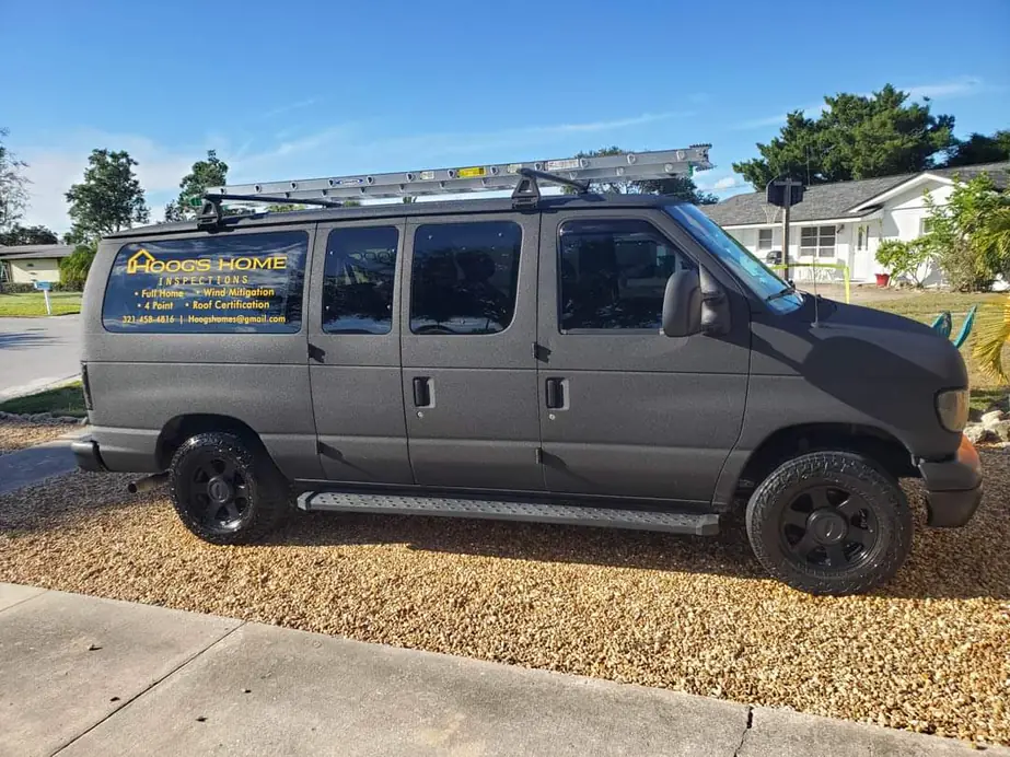 The Hoog's Home Inspections van, lettered Full Home, Wind Mitigation, 4 Point and Roof Certification, parked on gravel outside a Florida ranch house